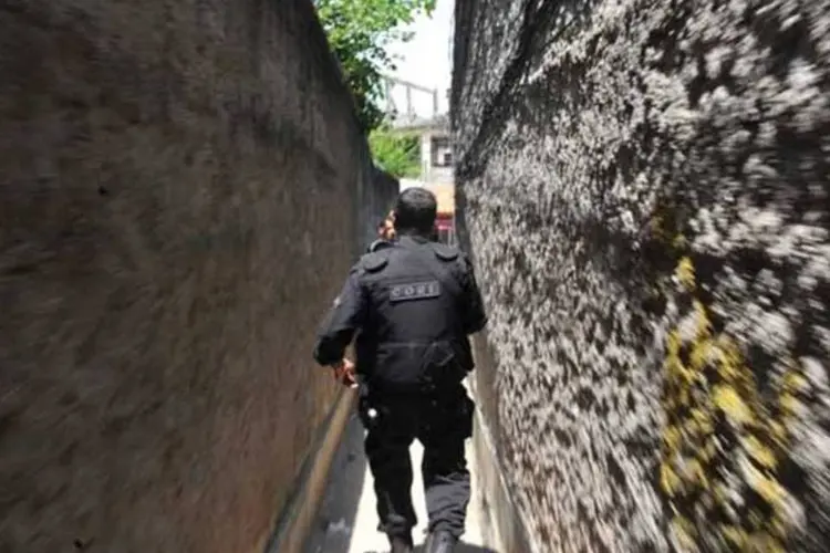 Policial caminha por beco no Complexo do Alemão, no Rio de Janeiro: UPP instalada no local sofreu o ataque que causou a morte de uma policial (Marcello Casal Jr./AGÊNCIA BRASIL)