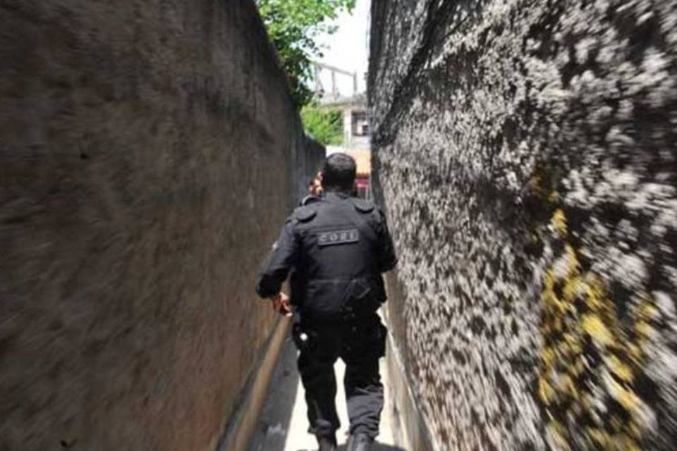 Policial caminha por beco no Complexo do Alemão, no Rio de Janeiro (Marcello Casal Jr./AGÊNCIA BRASIL)