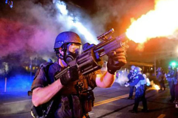 
	Foto cedida pelo The St. Louis Post Dispatch, tirada por David Carson, mostra policial disparando g&aacute;s contra manifestantes em Ferguson, Missouri: a equipe do The St. Louis Dispatch ganhou o Pulitzer de Furo de Reportagem Fotogr&aacute;fica
 (David Carson/AFP)