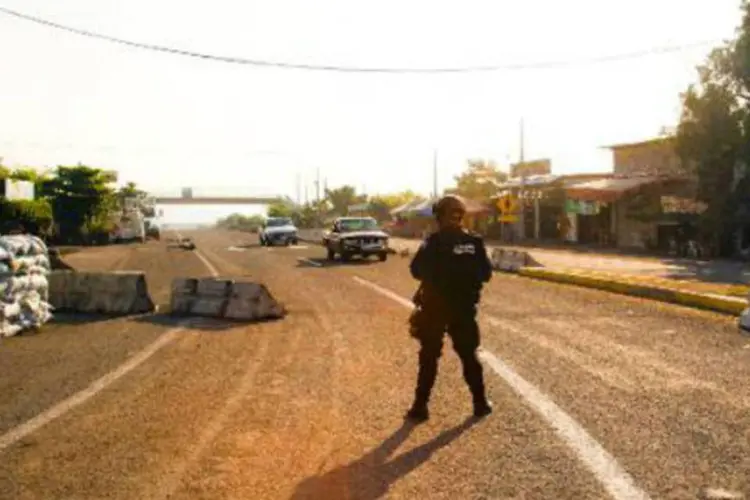 
	Policial vigia uma rua de Nueva Italia: um total de 9.300 membros da Pol&iacute;cia Federal e do Ex&eacute;rcito do M&eacute;xico&nbsp;foram mobilizados no estado de Michoac&aacute;n&nbsp;
 (AFP)