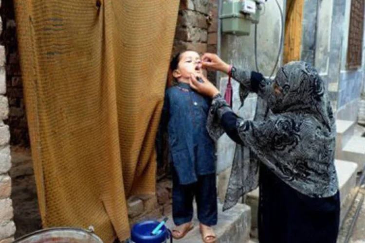 
	Funcion&aacute;ria dos servi&ccedil;os de sa&uacute;de d&aacute; vacina a crian&ccedil;a em Peshawar, no Paquist&atilde;o: a recusa de muitos pais em vacinar os filhos no pa&iacute;s &eacute; um dos obst&aacute;culos para eliminar a doen&ccedil;a
 (A. Majeed/AFP)
