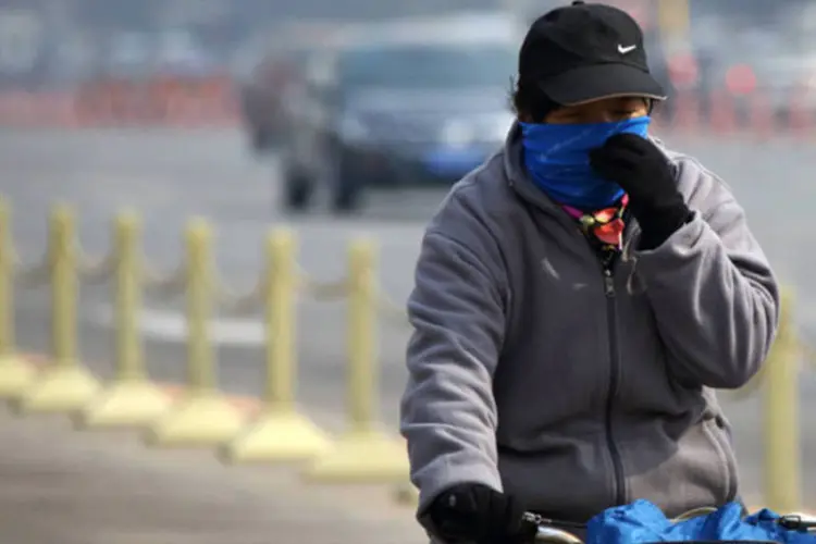 
	Mulher cobre o rosto para se proteger da polui&ccedil;&atilde;o enquanto anda de bicicleta: Treze de 15 empresas fiscalizadas em Linyi violaram leis ambientais
 (Tomohiro Ohsumi/Bloomberg)