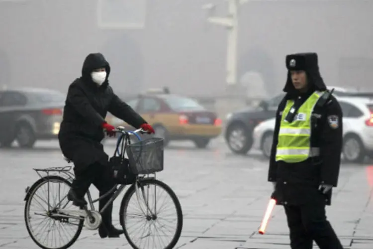 
	Chin&ecirc;s anda de bicicleta em meio &agrave; nuvem de polui&ccedil;&atilde;o que cobre Pequim
 (REUTERS/China Daily)