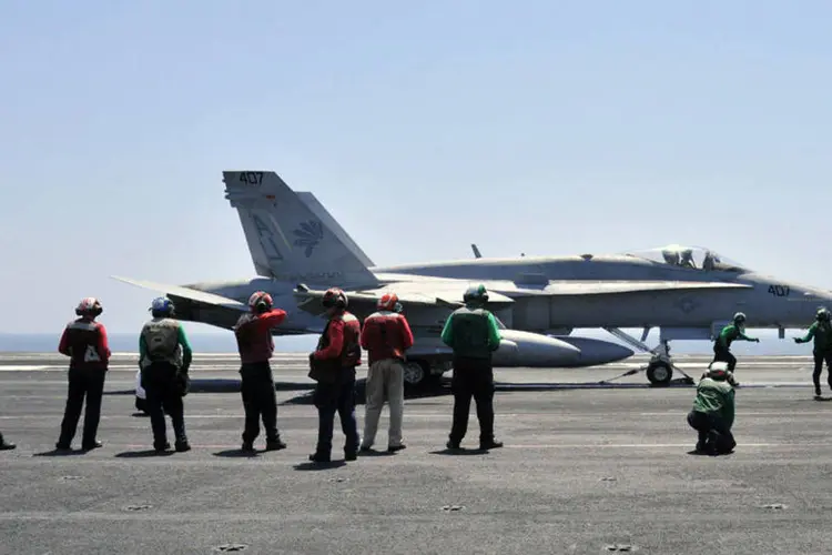 Inspeções finais no jato F/A-18C Hornet no porta-aviões USS George H.W. Bush no Golfo (Divulgação/Marinha dos EUA)