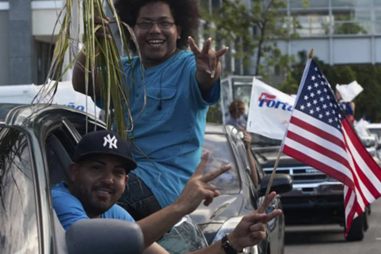 
	Partid&aacute;rios do Partido Novo Progressivo empunham bandeiras americanas ap&oacute;s dar seu voto para eleger o governo local e participar do plebiscito sobre a rela&ccedil;&atilde;o do pa&iacute;s com os EUA
 (Ana Martinez/Reuters)