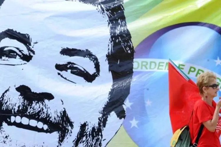 Mulher passa em frente a painel com rosto de Lula (Fabio Rodrigues/Agência Brasil)