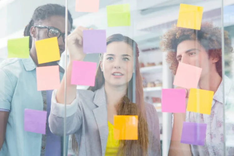 Jovens empreendedores olham para post-its (4774344sean/Thinkstock/Thinkstock)