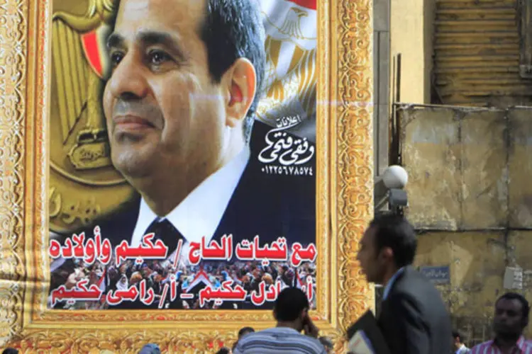 
	Pessoas passam por um p&ocirc;ster do general Abdel Fattah al-Sisi no centro de Cairo, no Egito: ex-chefe do ex&eacute;rcito &eacute; o favorito na elei&ccedil;&atilde;o presidencial
 (Mohamed Abd El Ghany/Reuters)