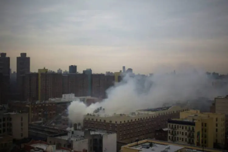 
	Fuma&ccedil;a sai de pr&eacute;dio ap&oacute;s explos&atilde;o em Nova York: Imagens de televis&atilde;o mostraram uma nuvem de fuma&ccedil;a e poeira sobre os escombros e os bombeiros jogando &aacute;gua
 (Eric Thayer/Reuters)