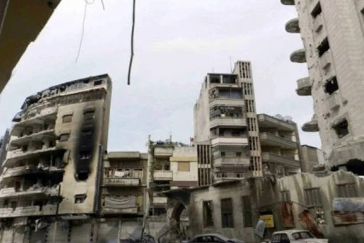 Prédios e carros destruídos em Homs, onde o Exército Livre Sírio, composto por soldados desertores, terá seu primeiro conselho militar local (AFP)