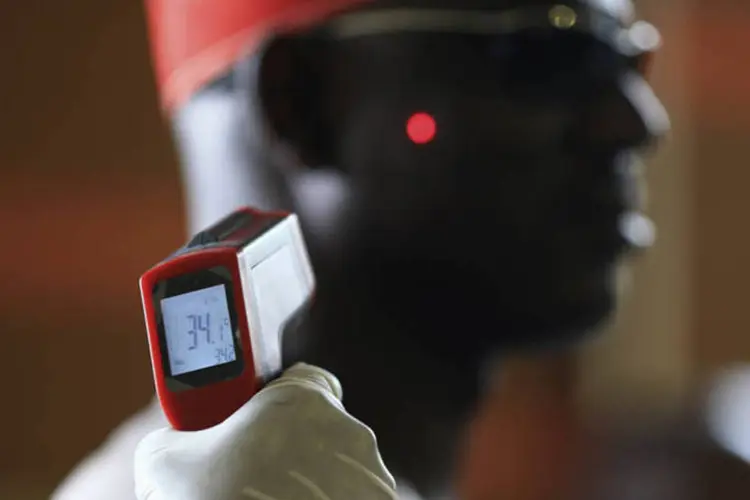 Homem tem a temperatura aferida em termômetro digital por prevenção contra o vírus ebola no aeroporto internacional de Abuja, na Nigéria (Afolabi Sotunde/Reuters)