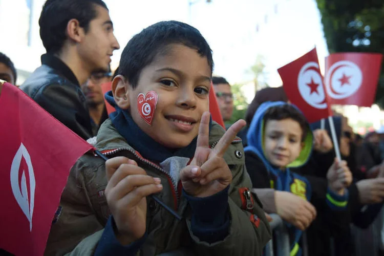 
	Primavera &Aacute;rabe: em fam&iacute;lia ou com amigos, muitos agitavam bandeiras tunisinas sob os olhares de um grande n&uacute;mero de policiais mobilizados
 (Fethi Belaid / AFP)