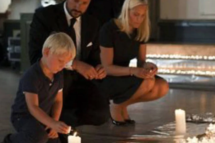 A princesa Mette-Marit acende velas na Catedral de Oslo em homenagens às vítimas do massacre, ao lado do marido, o príncipe herdeiro Haakon, e dos filhos ( Jan Johannessen/AFP)