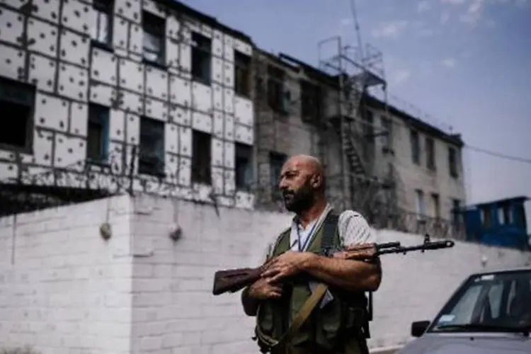 Militante rebelde patrulha prisão de segurança máxima bombardeada em Donetsk (Dimitar Dilkoff/AFP)