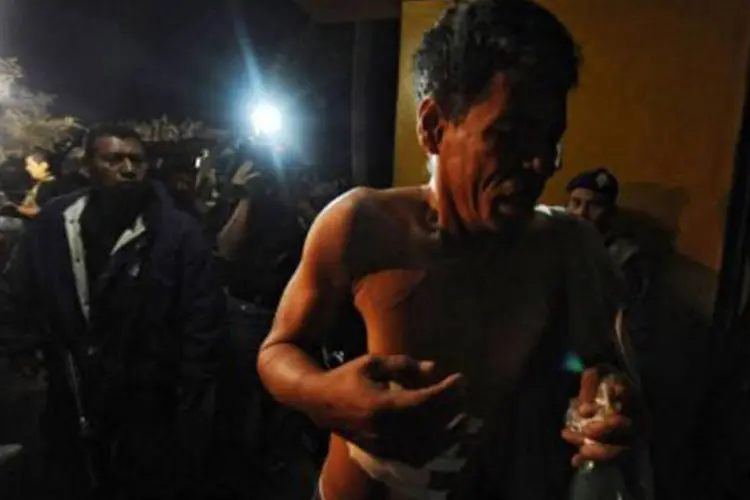 Detento sobrevivente de Honduras é socorrido pelos bombeiros: a polícia descarta que o incidente se trate de uma rebelião (Orlando Sierra/AFP)