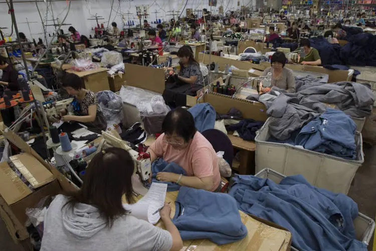Trabalhadores fazem casacos em fábrica em Brisbane, na Califórnia, Estados Unidos
 (David Paul Morris/Bloomberg)