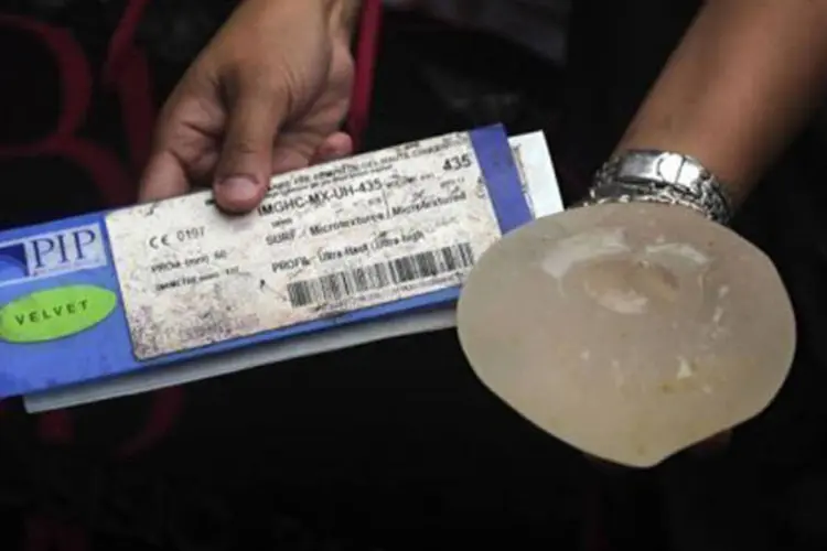 Usuária mostra um certificado e um implante da marca francesa PIP: há suspeitas de que o produto cause câncer de mama
 (Juan Barreto/AFP)
