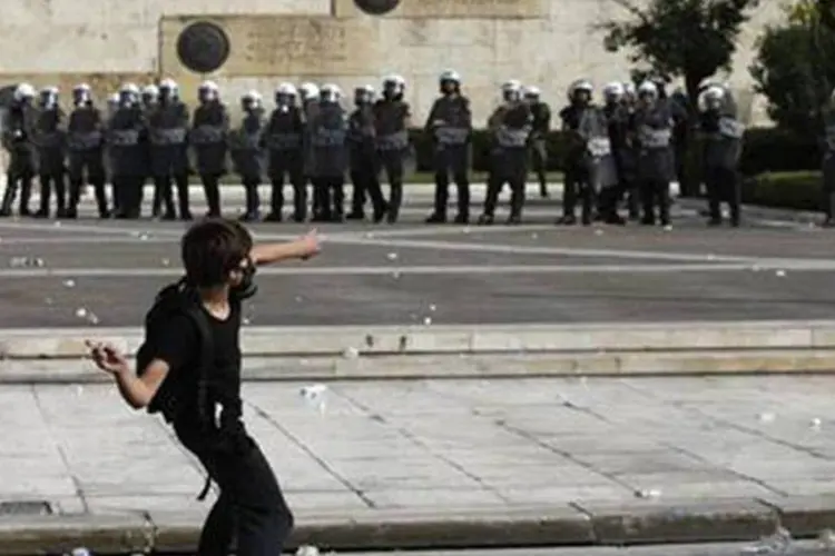 Manifestante joga pedra na polícia em protesto na Grécia (John Kolesidis/Reuters)