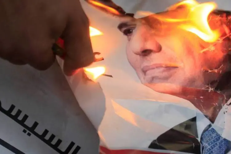 Manifestante queima um poster de Abdel Fattah al-Sisi, ex-chefe do Exército e favorito na eleição presidencial, durante um protesto próximo do palácio presidencial no Cairo, Egito (Amr Abdallah Dalsh/Reuters)