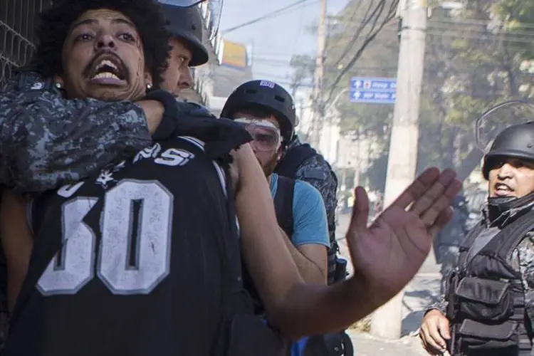 
	Policial prende um manifestante durante um protesto contra a Copa
 (Marco Bello/Reuters)