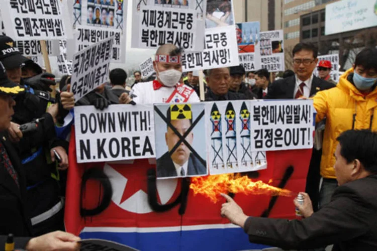 Manifestantes queimam a bandeira da Coreia do norte durante um protesto no centro de Seul, na Coreia do Sul (Kim Hong-Ji/Reuters)