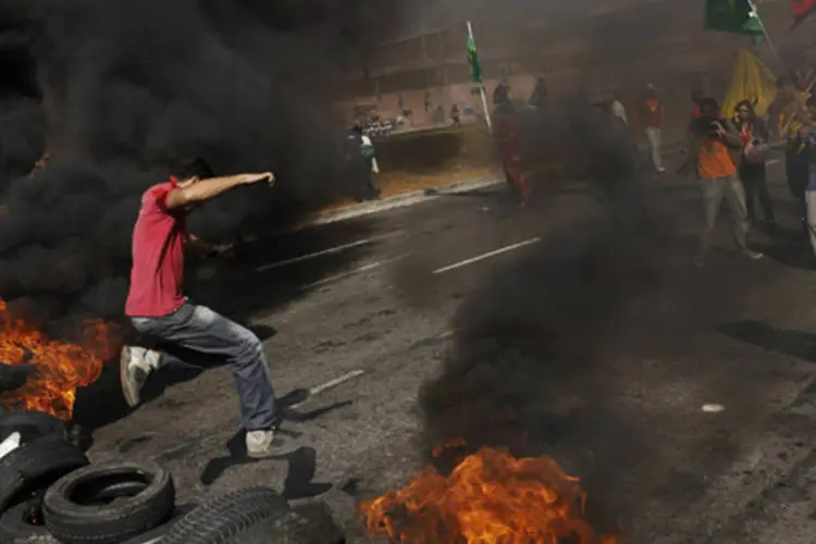 
	Homem salta barricada de pneus feita por manifestantes do MTST em Itaquera, durante o protesto da semana passada
 (REUTERS/Nacho Doce)