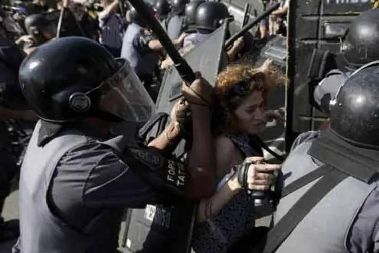 
	Mulher &eacute; empurrada pela Pol&iacute;cia Militar durante protestos contra a Copa
 (Reuters)