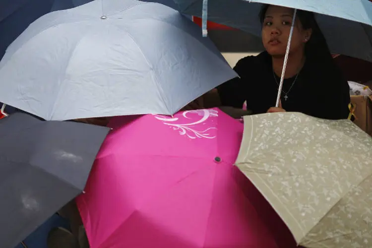 Manifestante abaixo de guarda-chuvas, durante protestos pró-democracia em Hong Kong (Carlos Barria/Reuters)