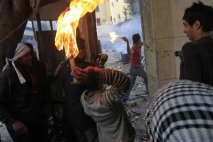 Manifestantes contrários ao governo militar egípcio se preparam para lançar bombas incendiárias (Mohammed Abed/AFP)