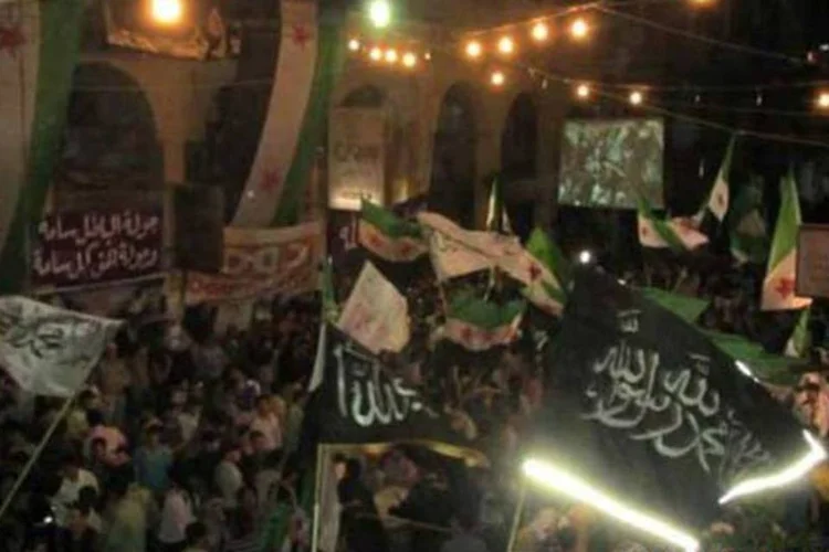 Imagem da Shaam News Network mostra um protesto contra o governo em Douma na noite de 21 de abril (AFP)