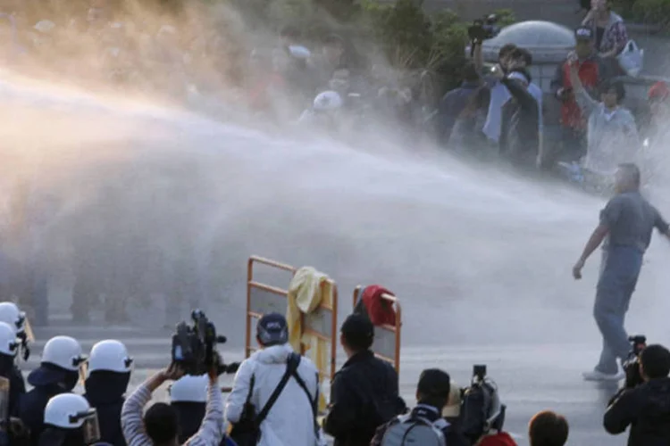 Policiais usam canham de água para dispersar manifestantes durante um protesto contra acordo de comércio assinado com a China, em Taiwan (Edward Lau/Reuters)