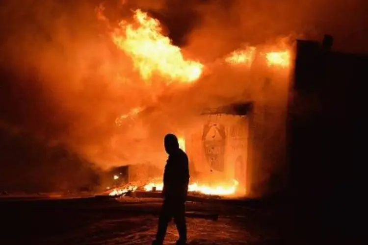 Loja incendiada durante protestos em Ferguson, Missouri, após o anúncio de que o policial que matou jovem negro desarmado não será indiciado (Michael B. Thomas/AFP)