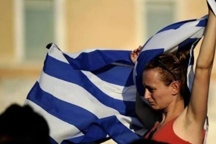 Jovem leva a bandeira grega durante um protesto contra o desemprego (Filippo Monteforte/AFP)