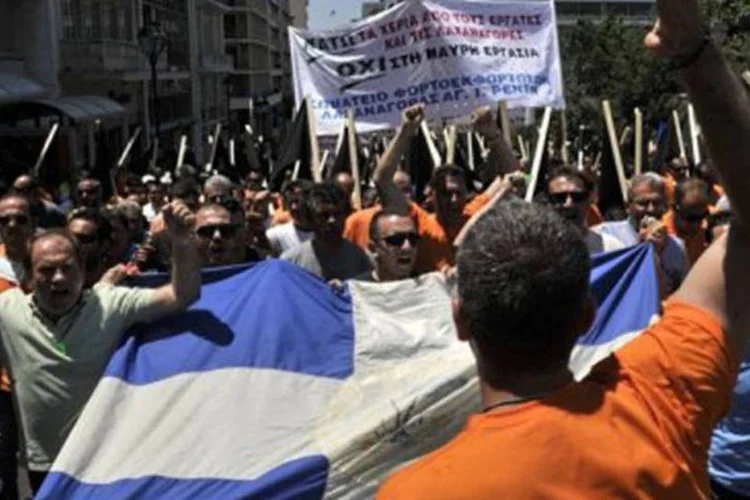 
	Trabalhadores carregam uma bandeira da Gr&eacute;cia em um novo protesto contra o desemprego: alguns gregos n&atilde;o confiam nos pol&iacute;ticos e dizem que precisam mudar a situa&ccedil;&atilde;o por si pr&oacute;prios
 (Louisa Gouliamaki/AFP)