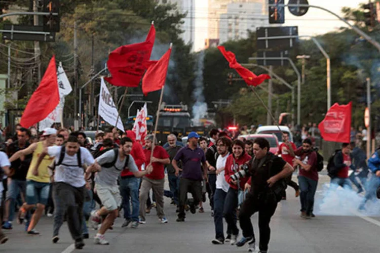 Manifestantes fogem de bombas de gás lacrimogêneo lançadas pela polícia durante protesto dos metroviários (REUTERS/Stringer/Brazil)