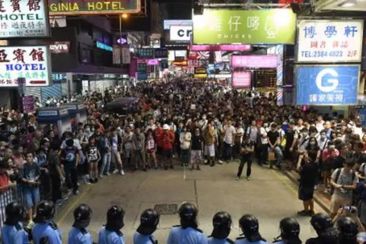 Manifestantes encaram policiais durante um protesto no distrito de Mongkok (Ed Jones/AFP)