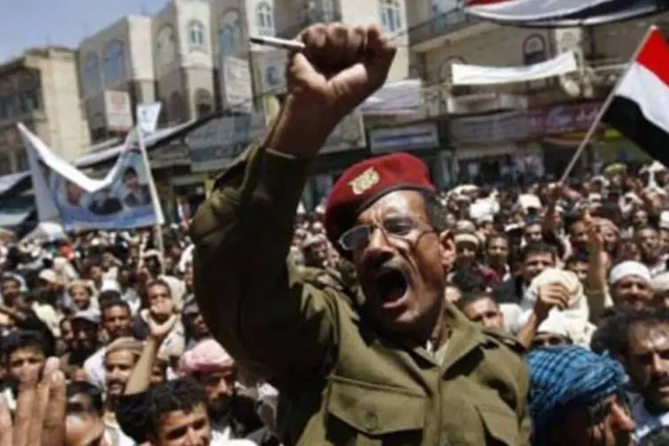 Militar iemenita é carregado por manifestantes durante protesto em Sanaa (Ahmad Gharabli/AFP)