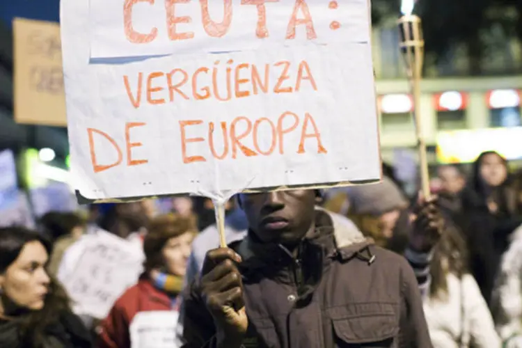 Imigrante segura um cartaz durante um protesto pela morte de imigrantes no enclave espanhol de Ceuta, em Madri, na Espanha (Juan Medina/Reuters)