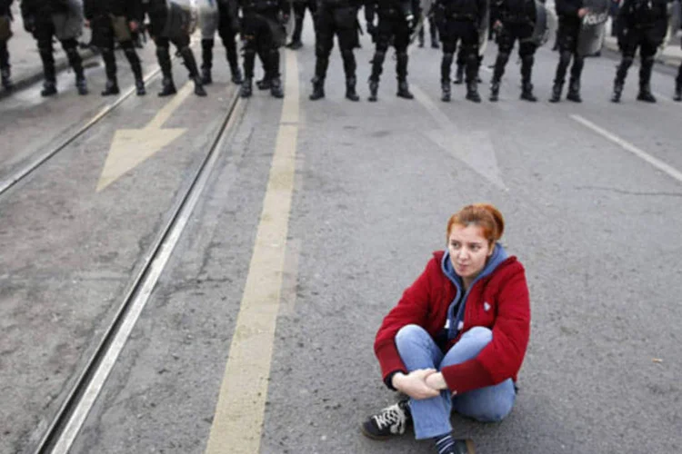 Manifestante anti-governo sente em frente a policiais durante protesto em Sarajevo, na Bósnia (Dado Ruvic/Reuters)