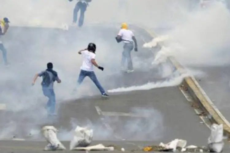 Opositores de Maduro enfrentam a polícia em Caracas: há três semanas, a Venezuela é sacudida por uma onda de protestos, iniciados no dia 4 de fevereiro, em San Cristóbal (AFP)