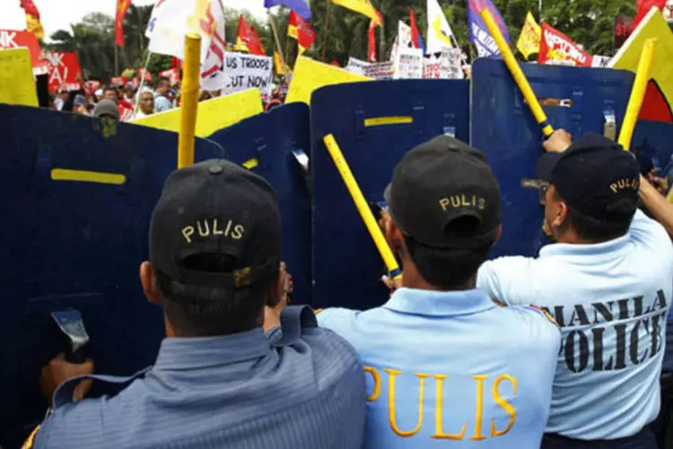 Policiais usam seus escudos para bloquear manifestantes durante protesto em frente à embaixada dos Estados Unidos em Manila, nas Filipinas (Romeo Ranoco/Reuters)