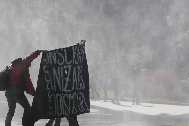 
	Chile: ocorreram alguns incidentes, quando grupos de encapuzados atacaram com pedras a pol&iacute;cia, que respondeu com gases lacrimog&ecirc;neos e jatos de &aacute;gua
 (Rodrigo Garrido / Reuters)