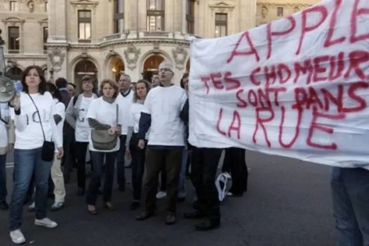 Funcionários da Apple francesa e ex-vendedores da marca desempregados protestam em frente à loja modelo durante lançamento do iPhone 5, em Paris (Jacky Naegelen/Reuters)