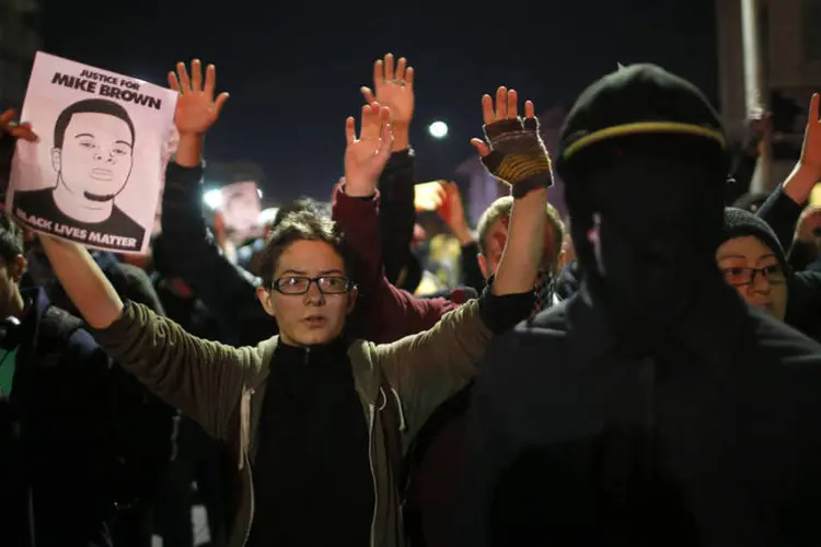 Manifestantes levantam as mãos durante protesto em solidariedade ao caso de Ferguson, em Oakland (Stephen Lam/Reuters)