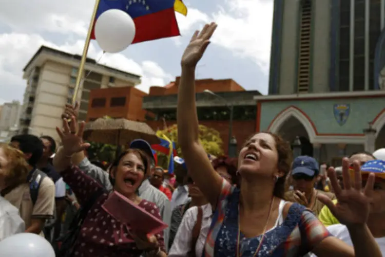 
	Manifestantes da oposi&ccedil;&atilde;o gritam do lado de fora de igreja de Nossa Senhora de Coromoto, em Caracas, Venezuela
 (Tomas Bravo/Reuters)