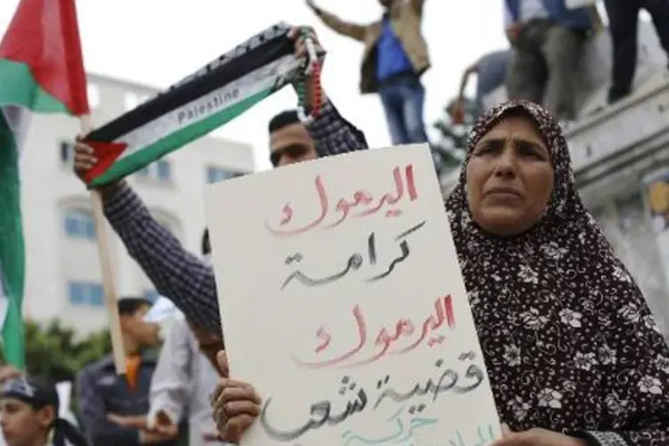 Palestinos manifestam em apoio a campo de Yarmuk: dirigente acrescentou que as forças palestinas trabalharão de forma integrada com o Estado sírio para "limpar o campo dos terroristas" (Mohammed Abed/AFP)