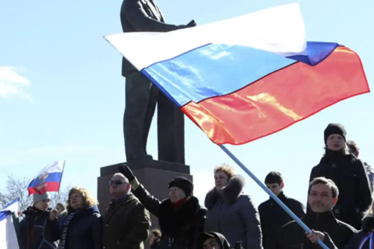 Participantes de uma manifestação pró-Rússia agitam bandeiras russas na frente da estátua de Lenin, em Simferopol (Sergei Karpukhin/Reuters)