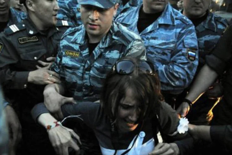 Policiais russos prendem mulher durante protesto em Moscou: os meios de comunicação oficiais alegaram que as multas são equivalentes às de outros países (Andrey Smirnov/AFP)