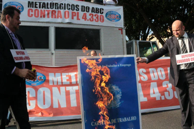 Manifestantes queimam cartaz com imagem da Carteira de Trabalho, em protesto contra a terceirização (Fabiano Ibidi/ SMABC)