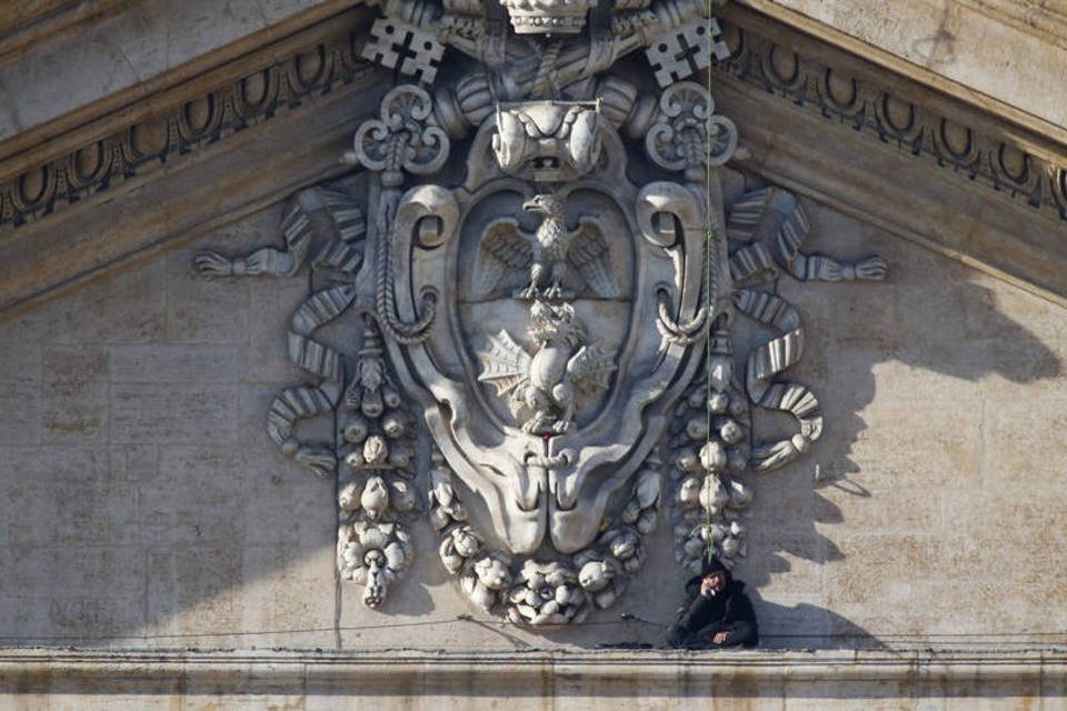 Homem protesta do alto da fachada da Basílica de São Pedro